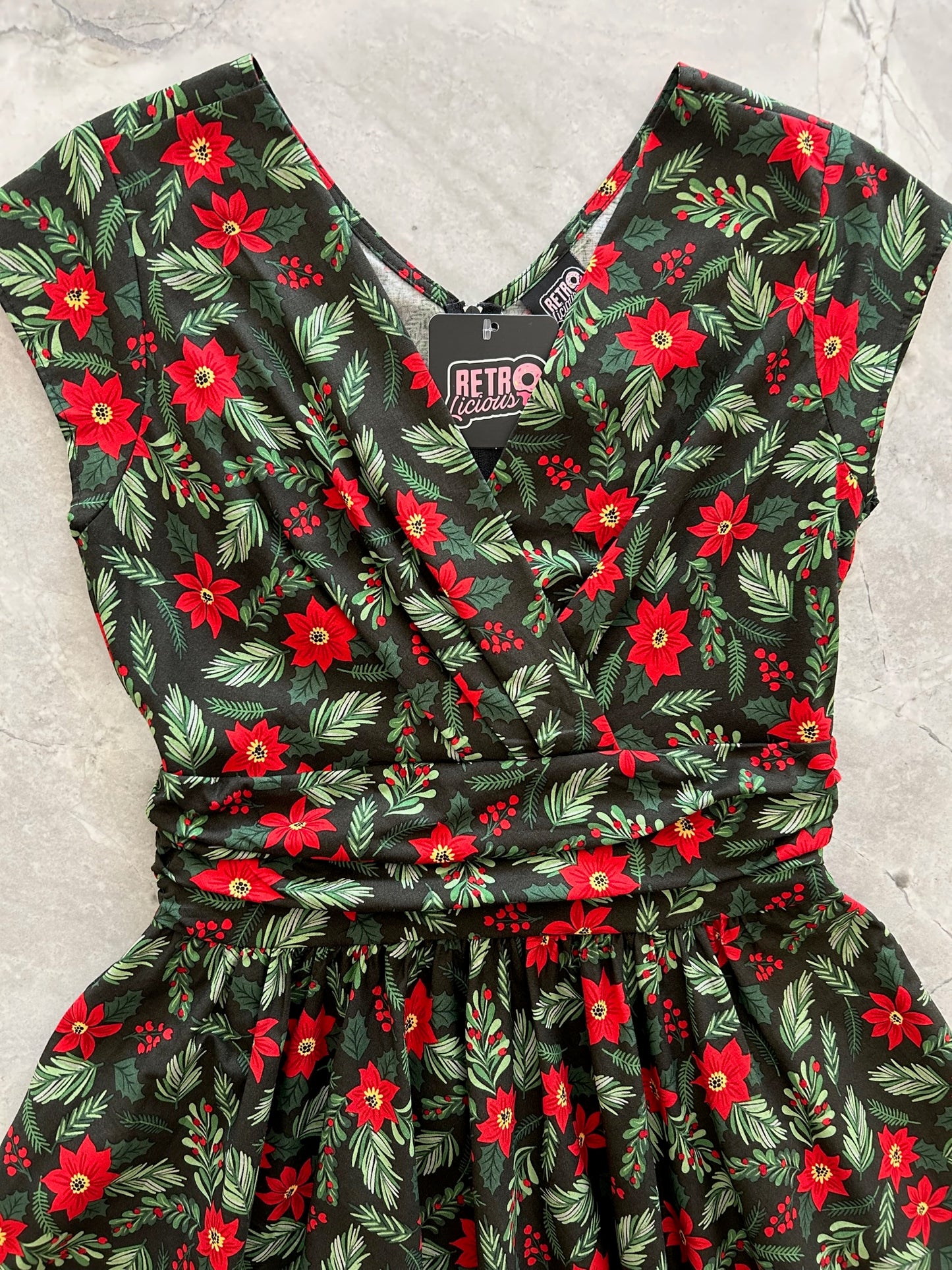 close up of the bodice of the holiday greta dress showing the surplus neckline and shirring at waist