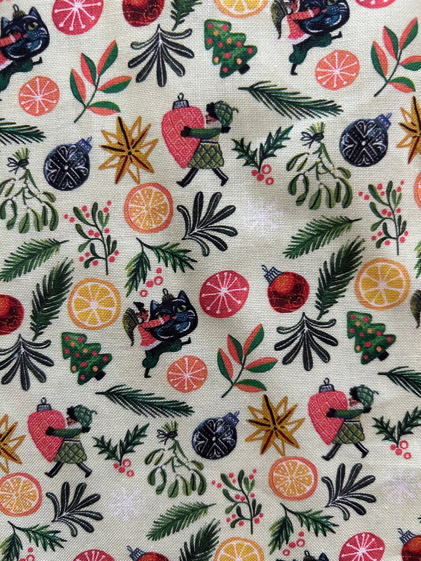 a close up of the print showing elves carrying hoiday ornaments