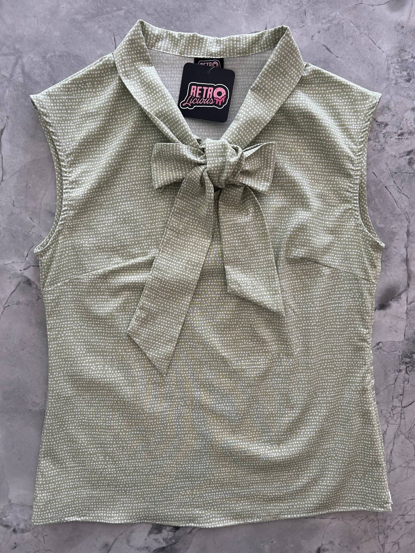 a flat lay of sage dot bow top 