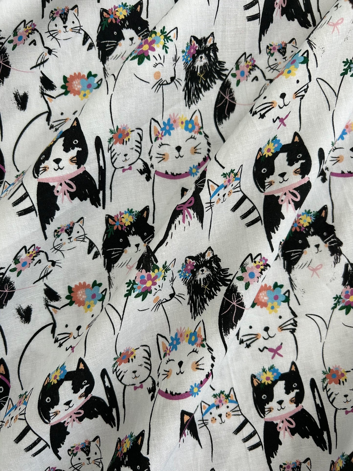 close up of the fabric showing the cats in their floral headbands