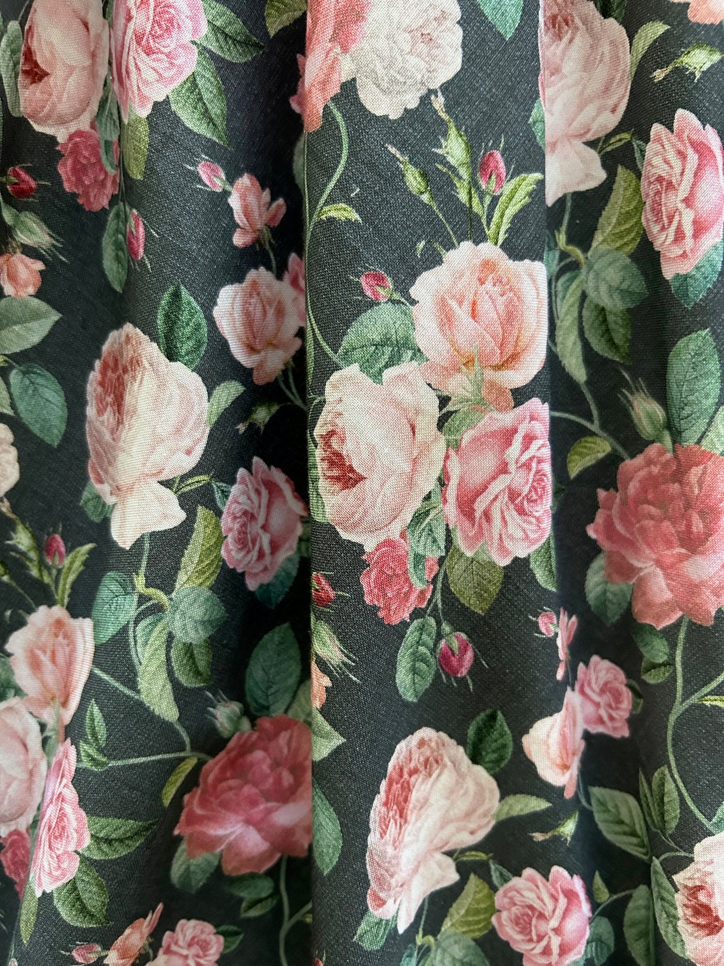 close up of fabric showing the pink roses on grey background