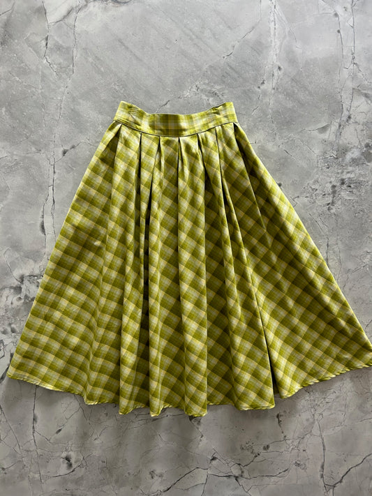 flatlay of the green plaid doris skirt showing the fullness of the skirt and the inverted pleats