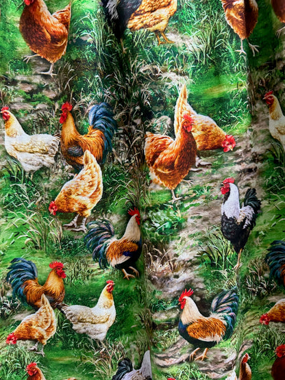 close up of fabric showing chickens on a grassy green background