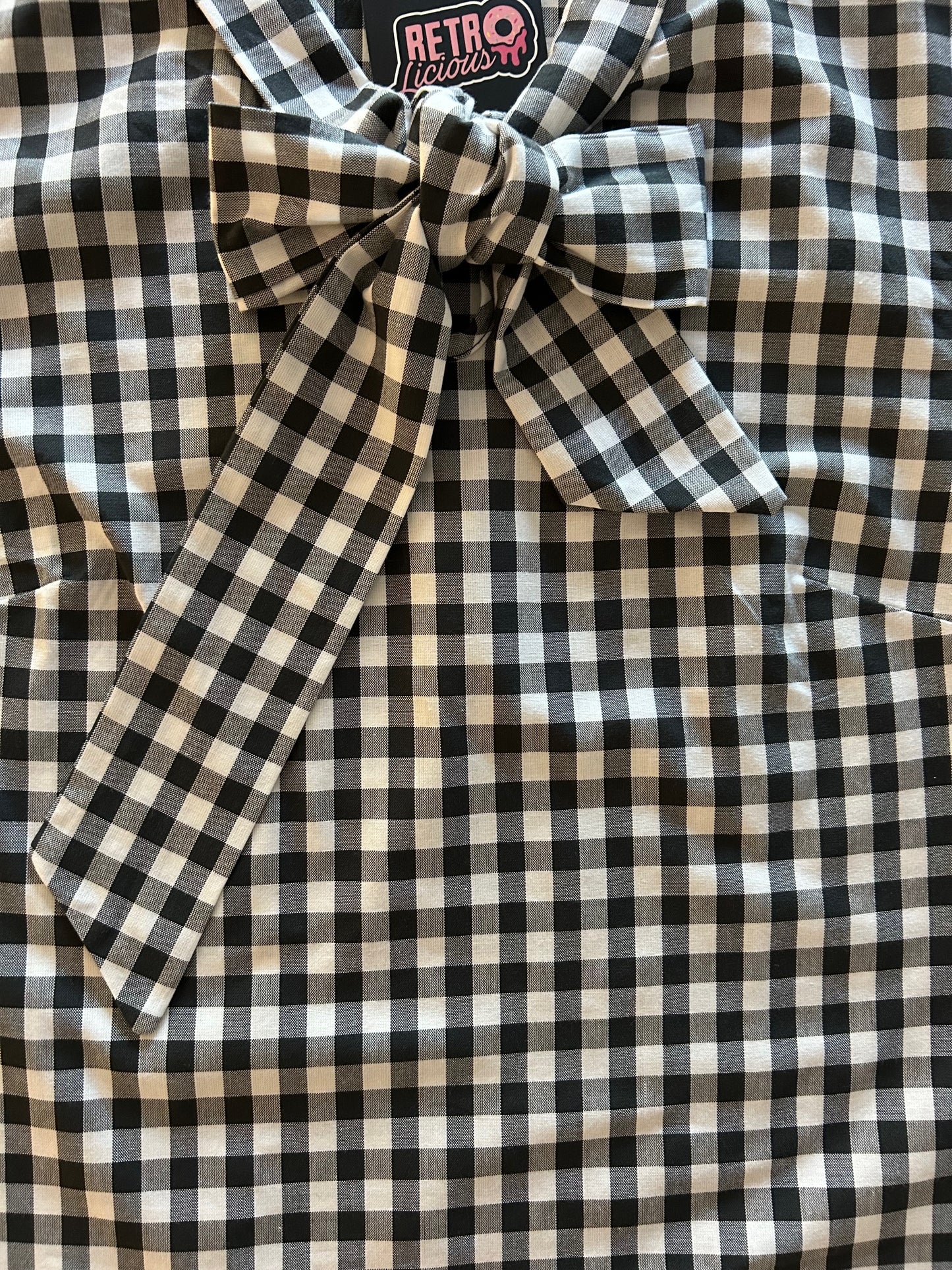 close up of black gingham top showing bow detail