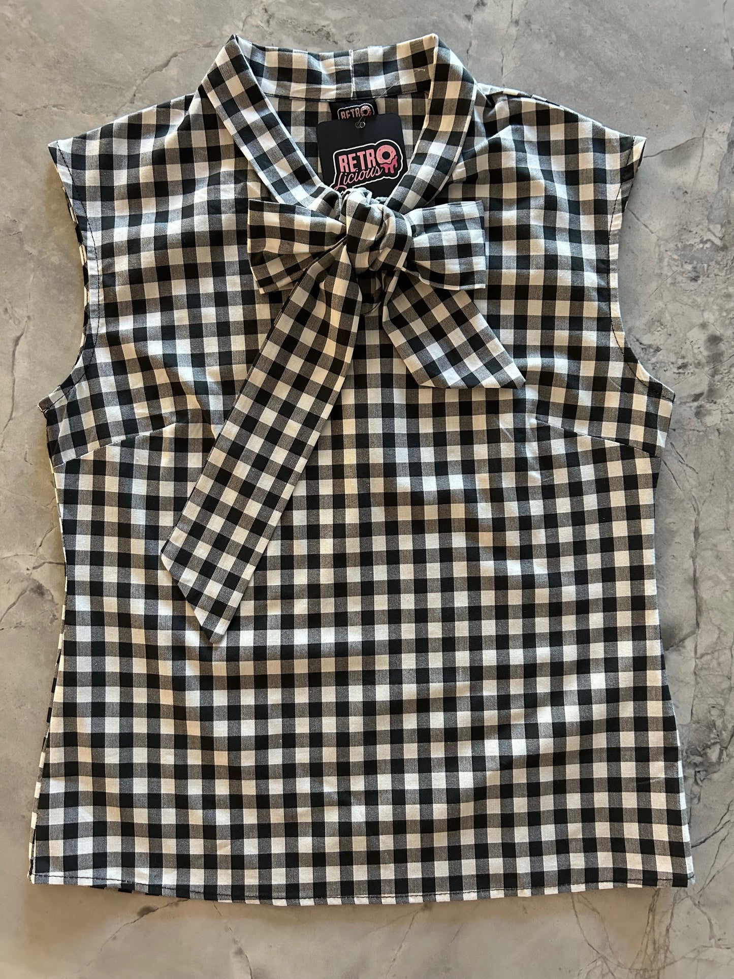 flatlay of black gingham bow top