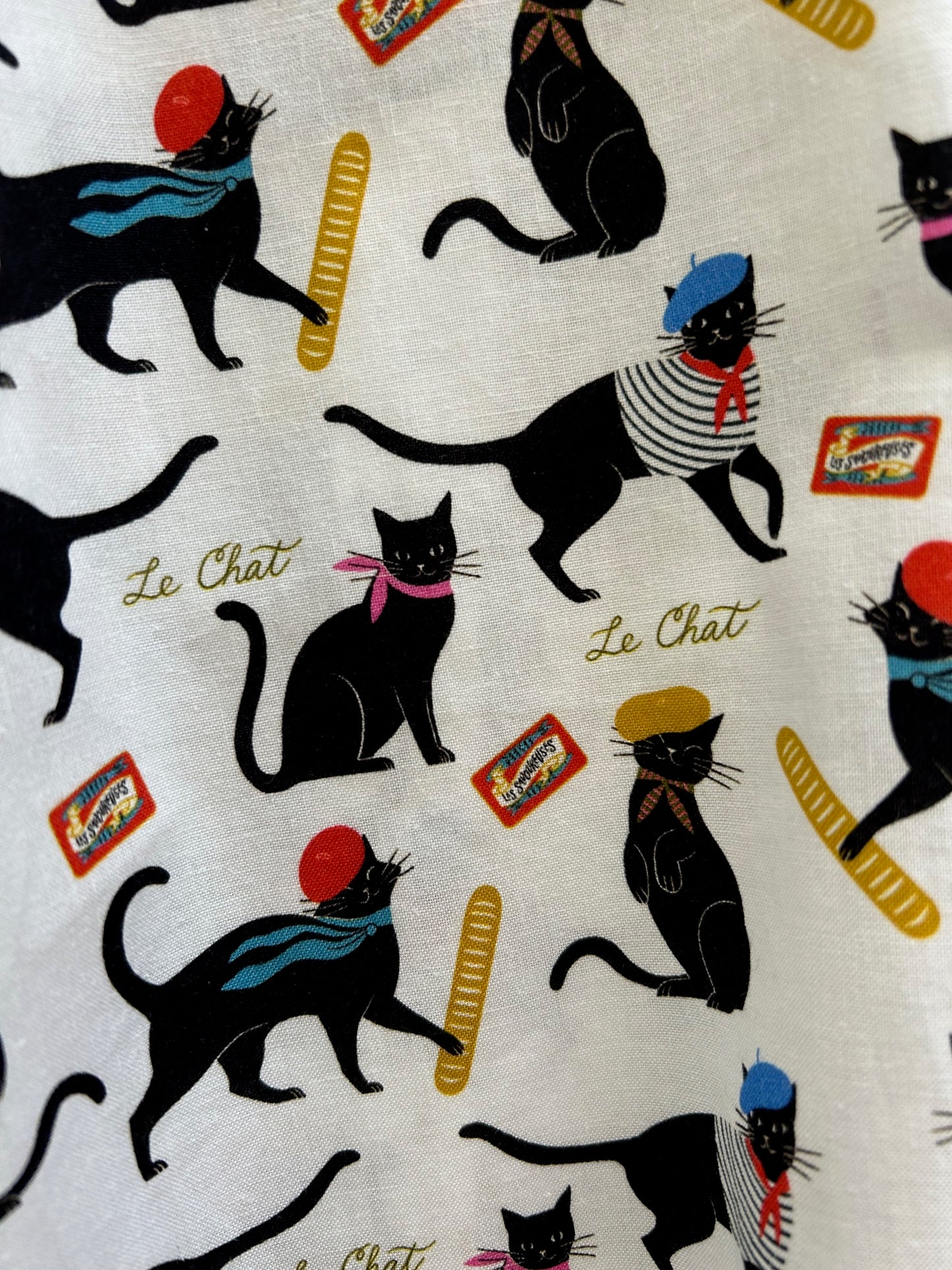 close up of fabric showing cats in berets and scarves