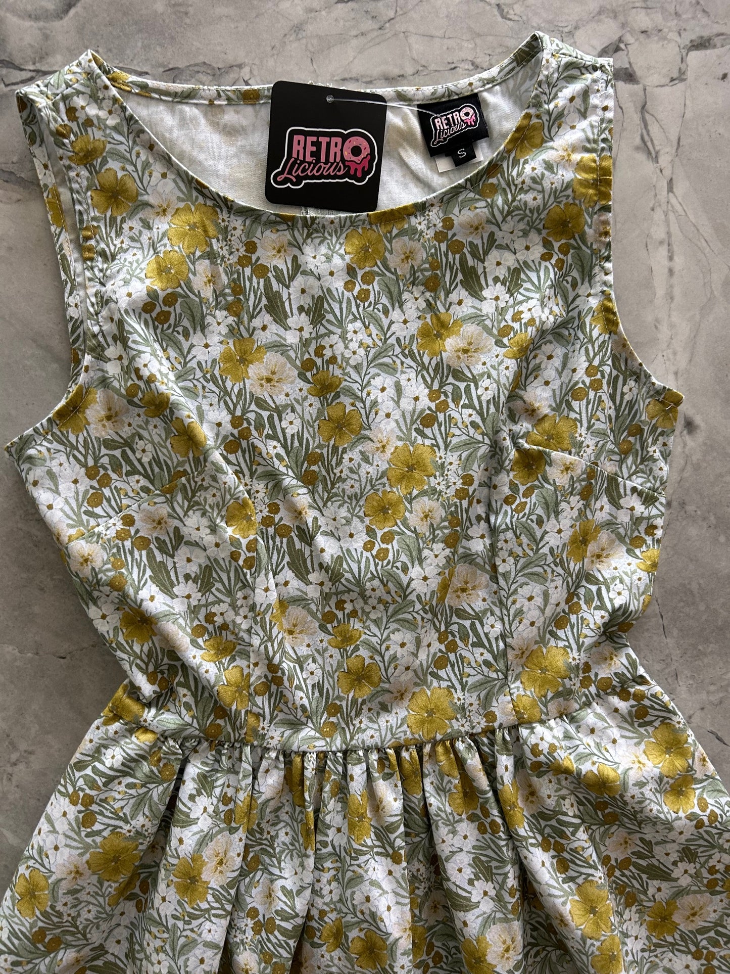 close up of bodice flatlay of mustard floral midi dress