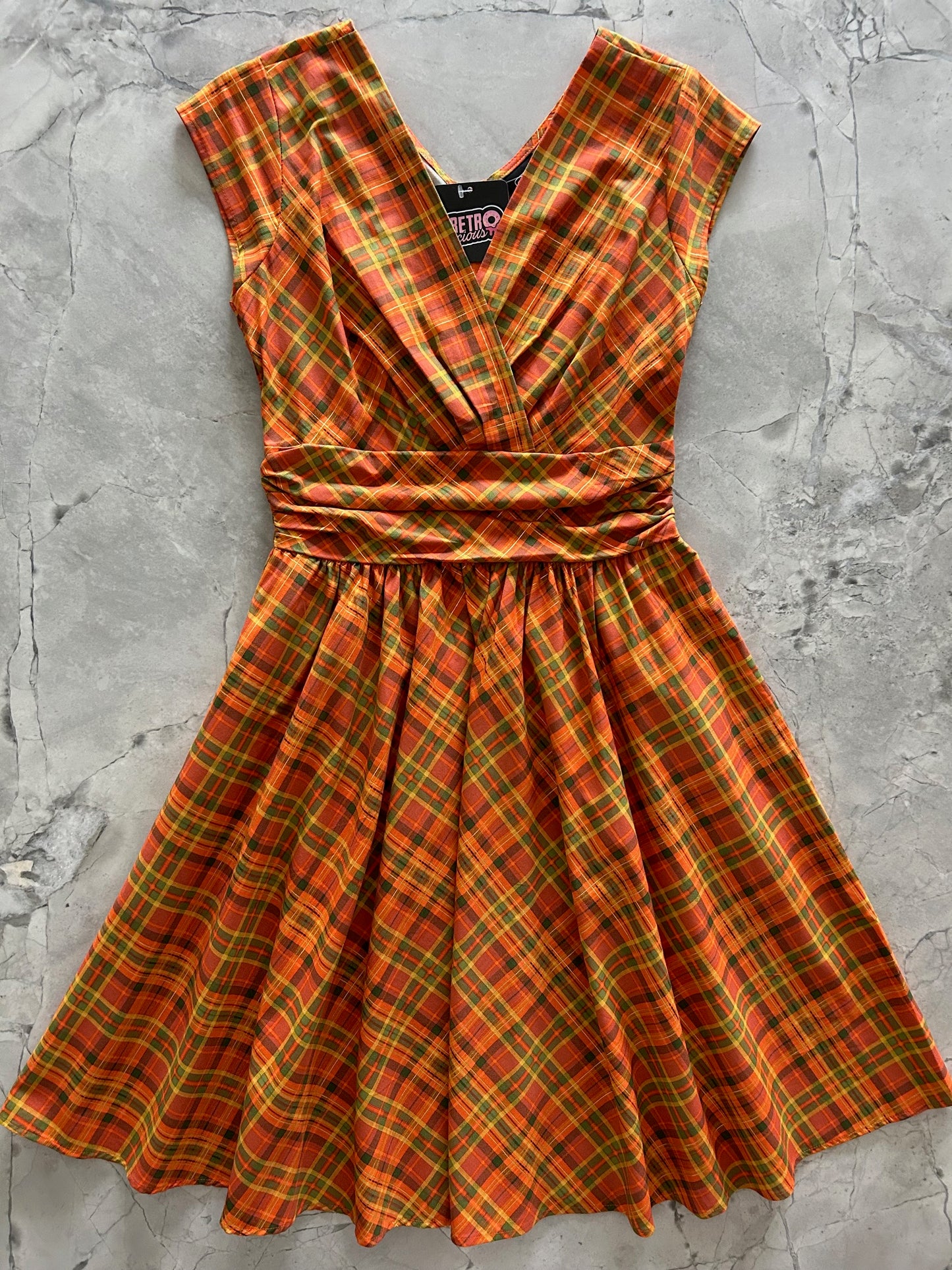 flatlay of orange plaid greta dress