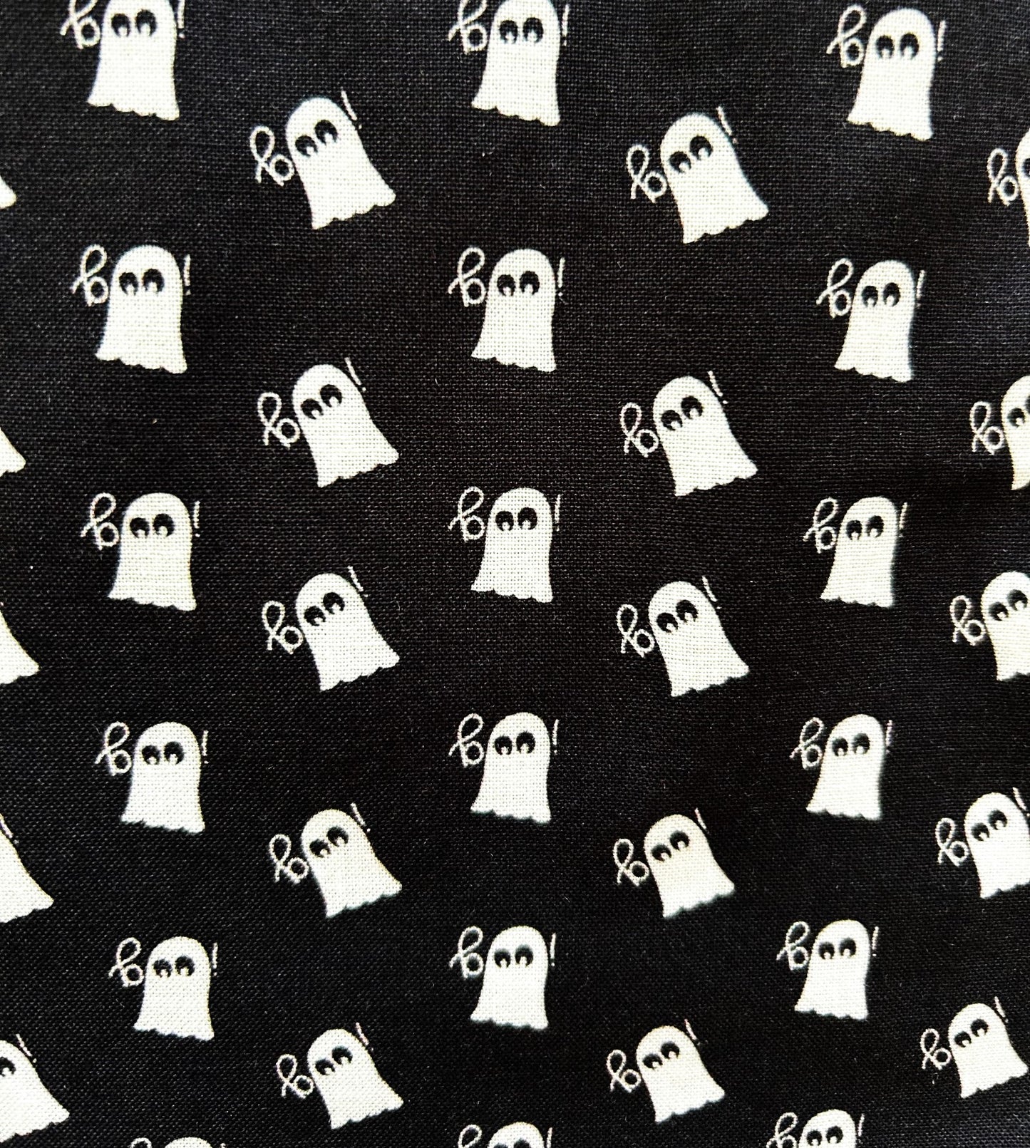close up of mini ghosts print on black background and white ghosts