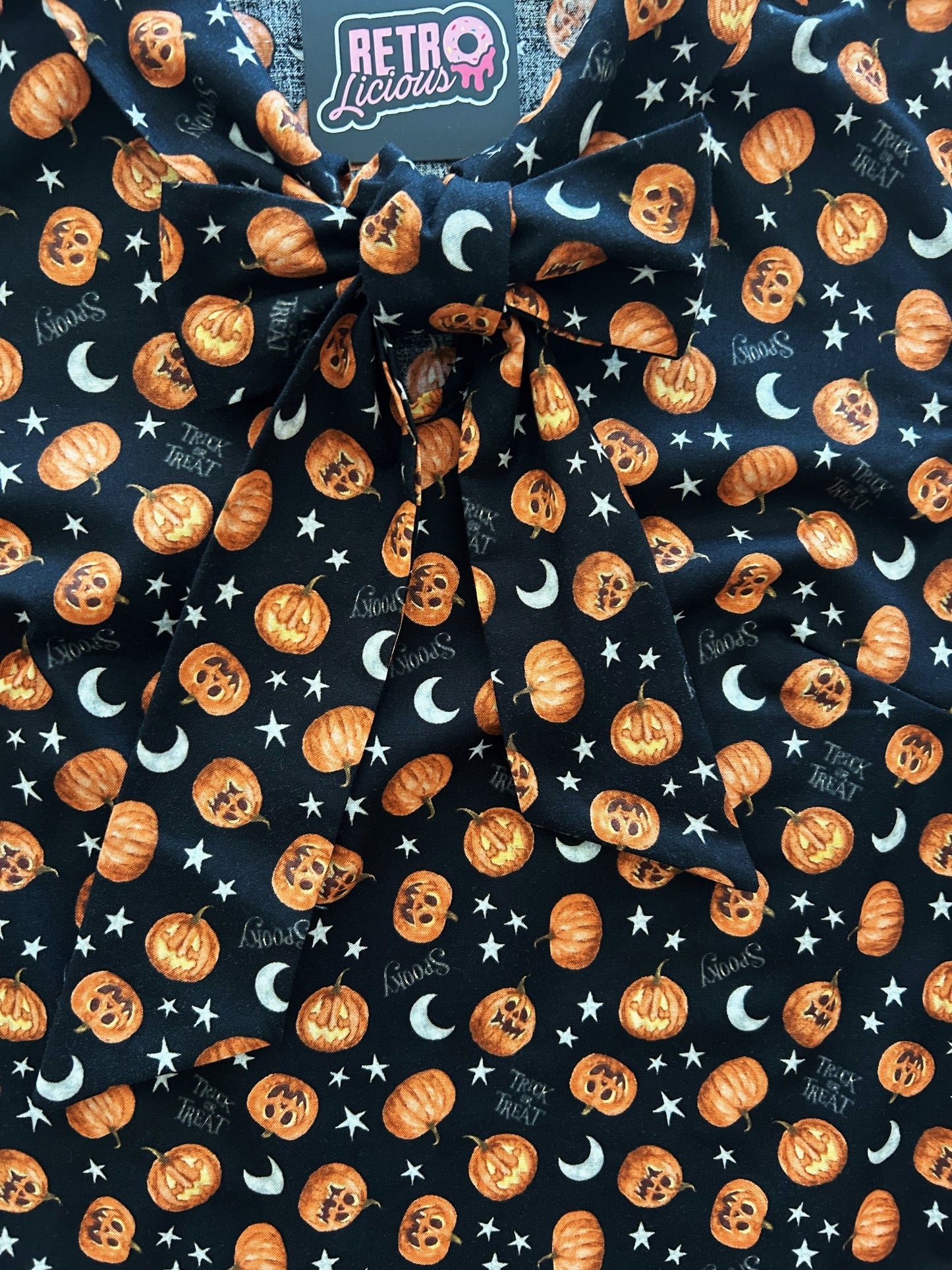 flatlay close up of jack-o-lantern bow top showing the front bow