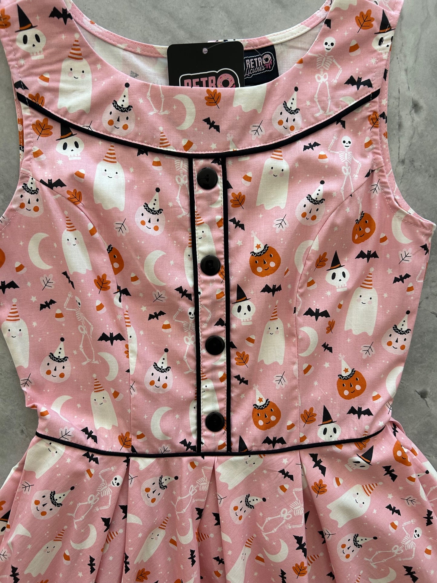 flatlay close up of bodice of elizabeth dress in pink halloween showing buttons and piping