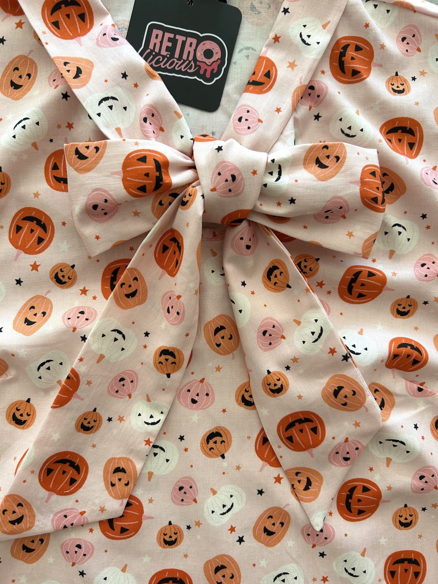 close up of pink jack-o-lantern bow top
