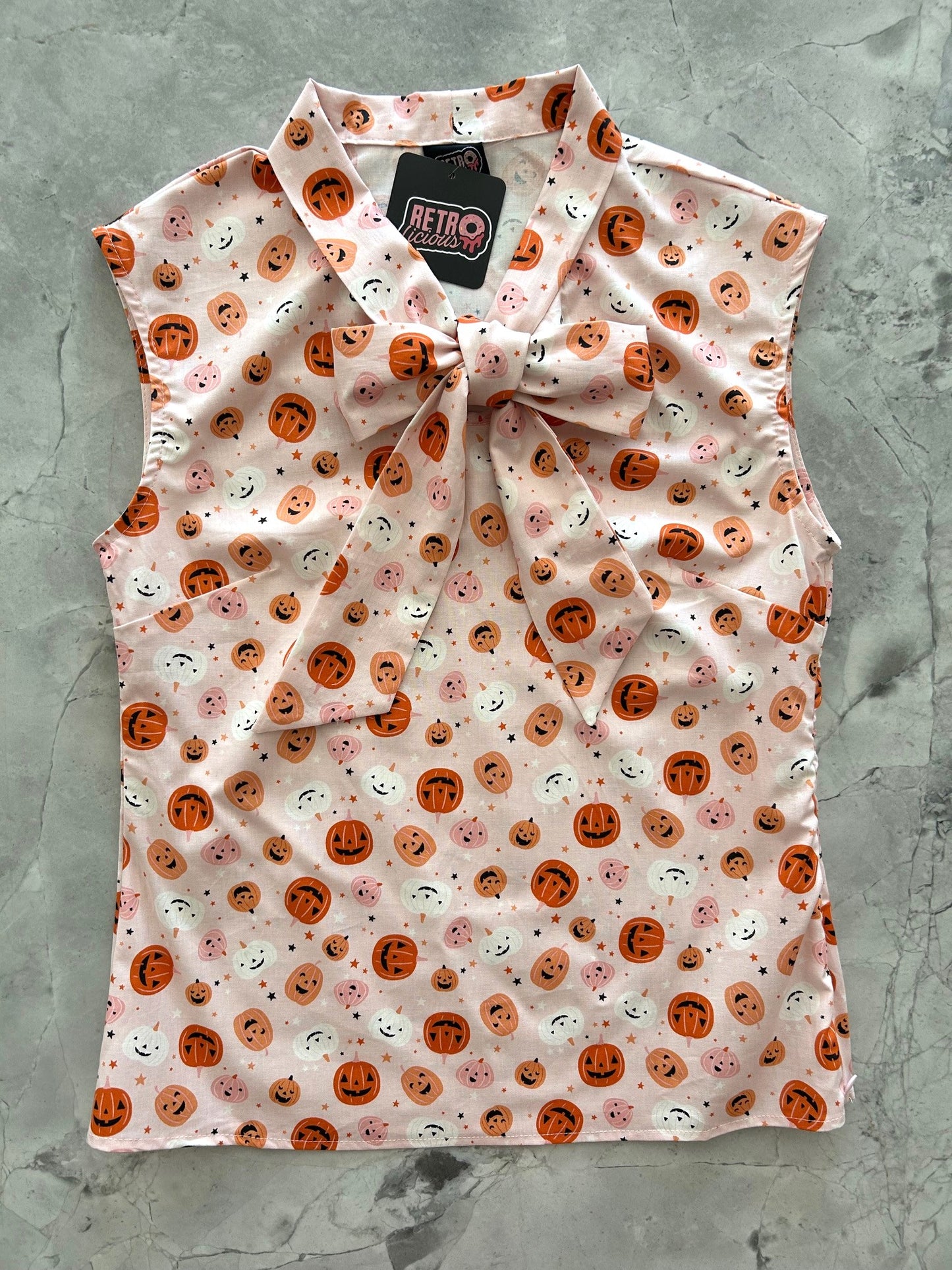flatlay of pink jack-o-lantern bow top
