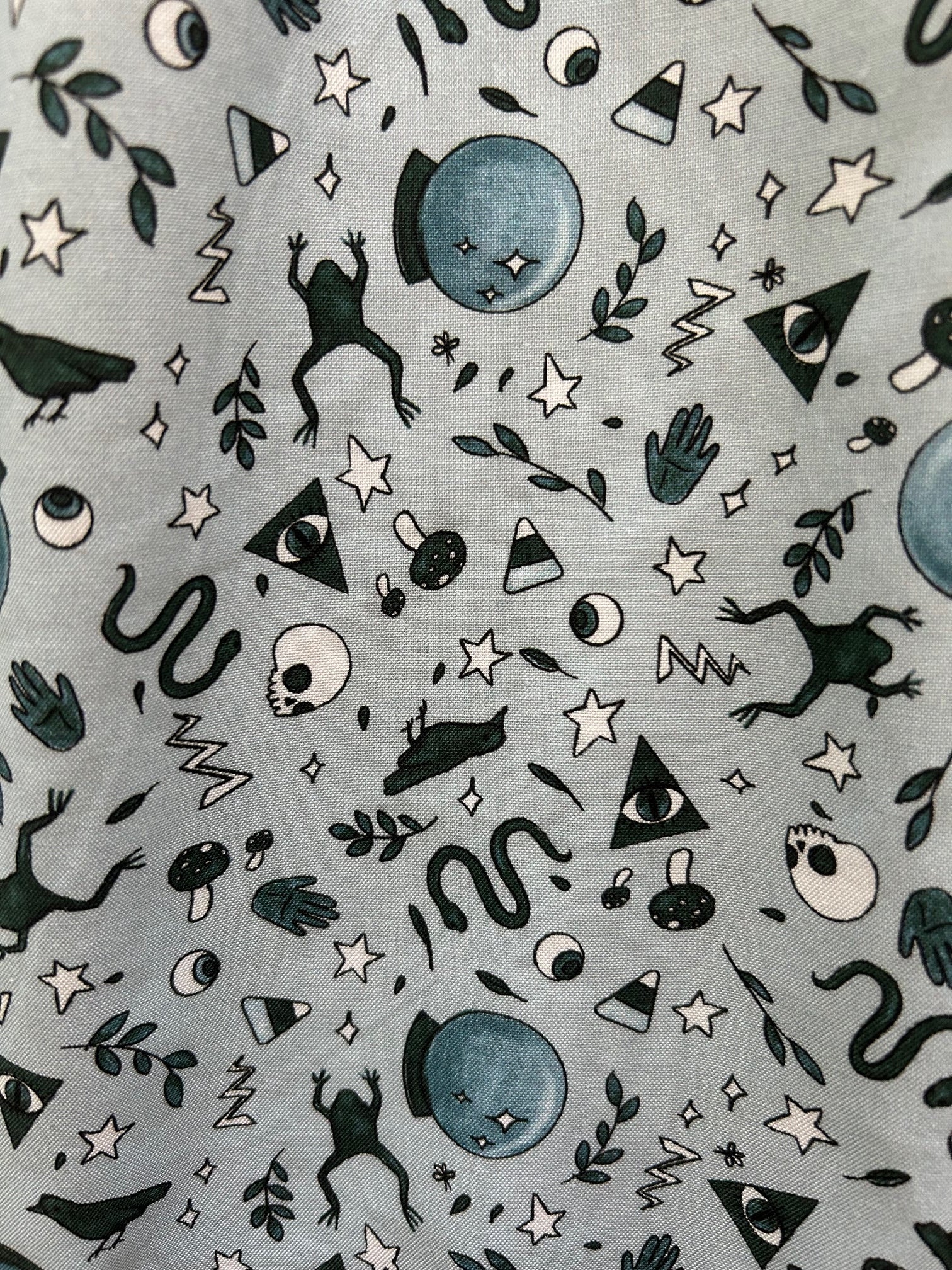 close up of fabric showing frogs, snakes, crystal ball of witching hour print