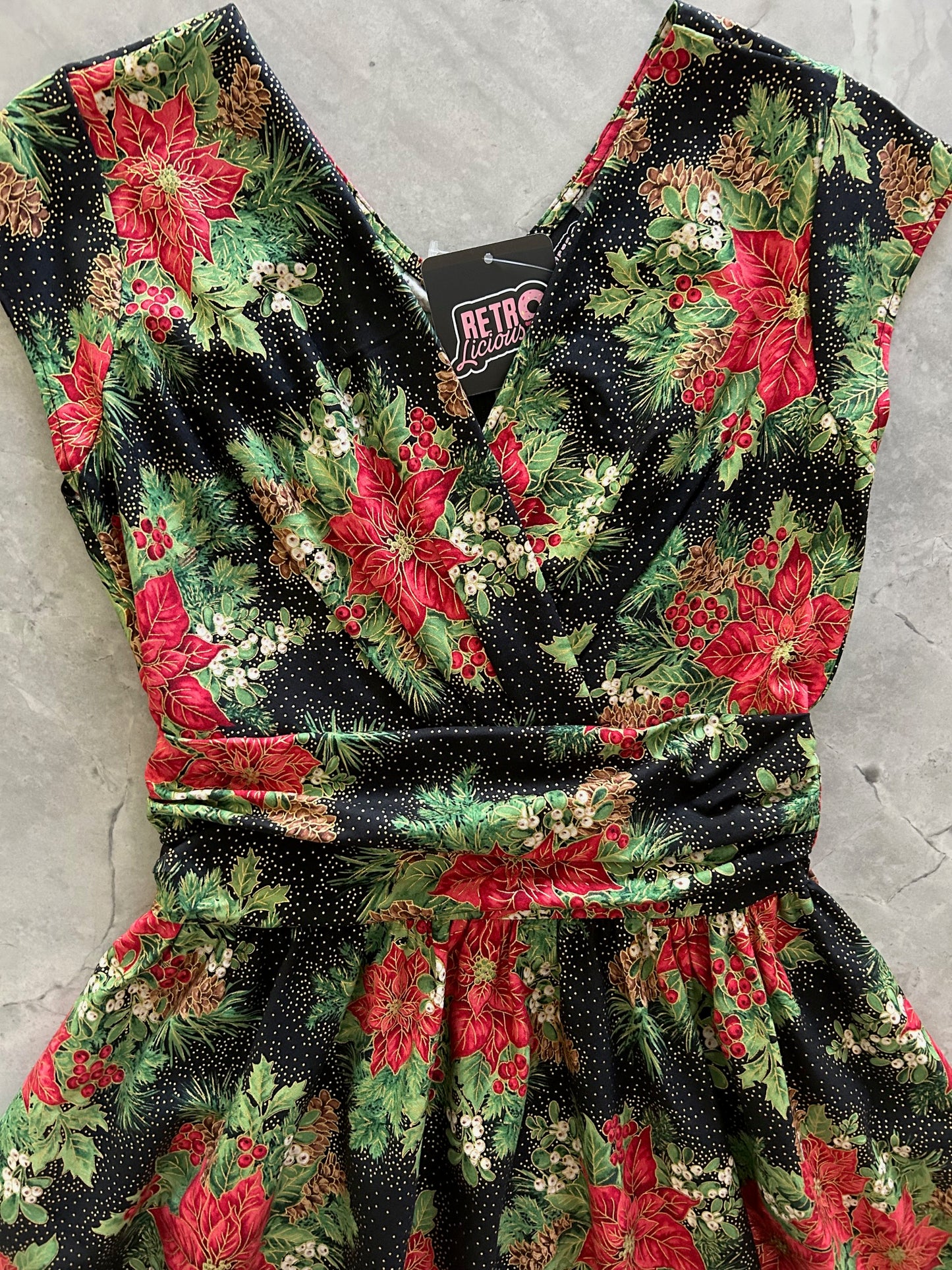 flatlay of the bodice of red poinsettias on black background greta dress