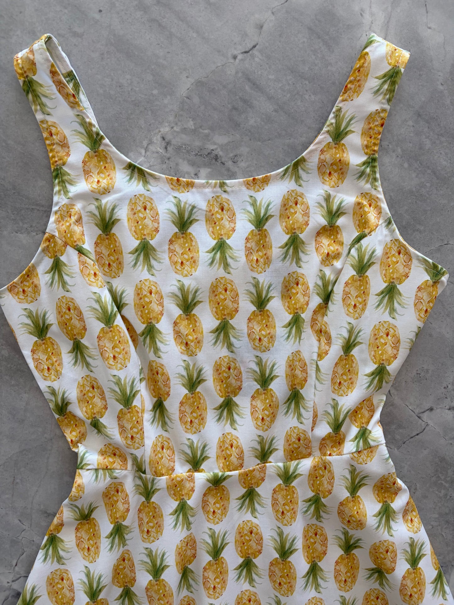Pineapple-patterned dress on a gray surface