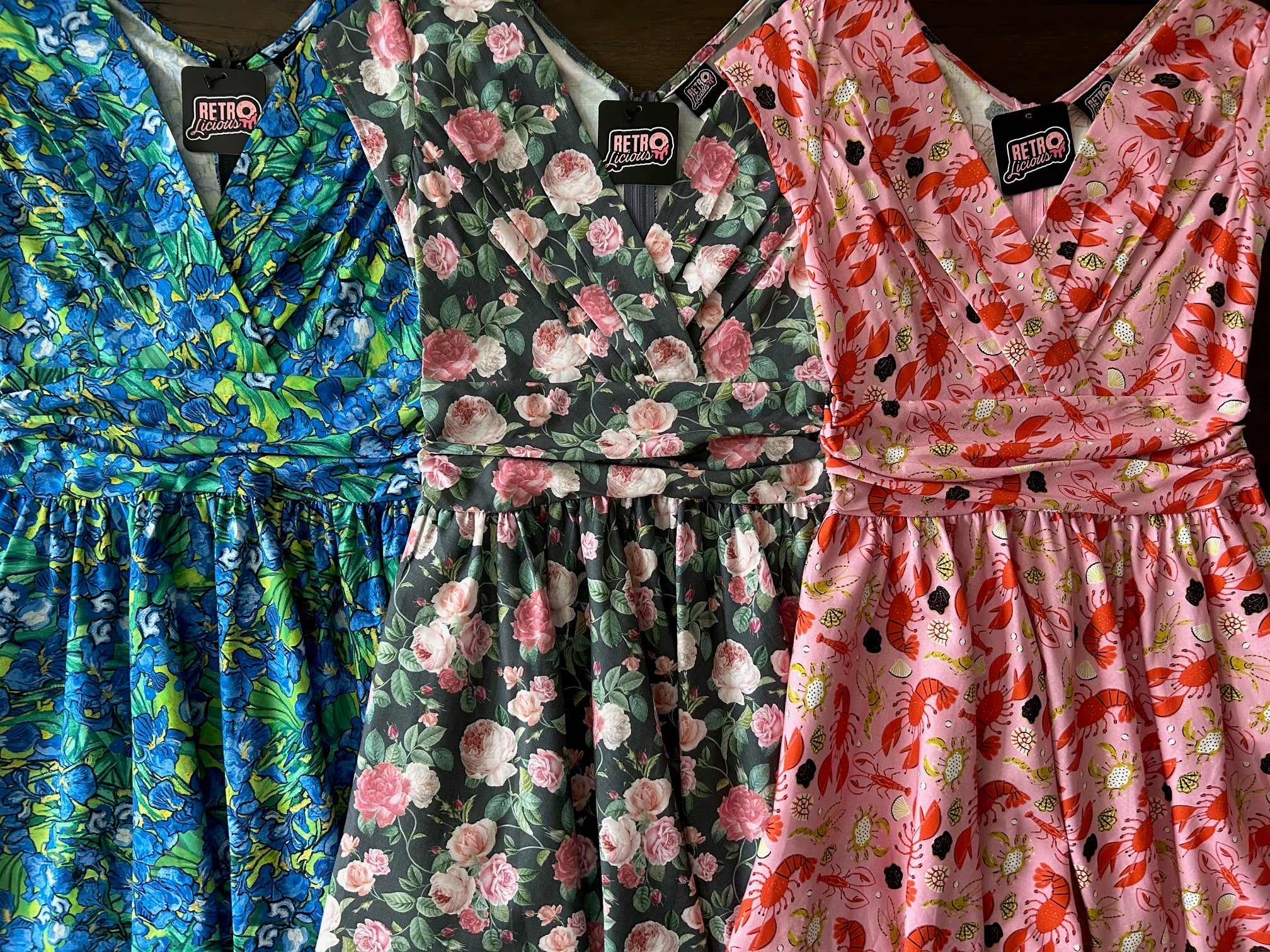 flat lay of three greta dresses in irises, roses and lobster prints