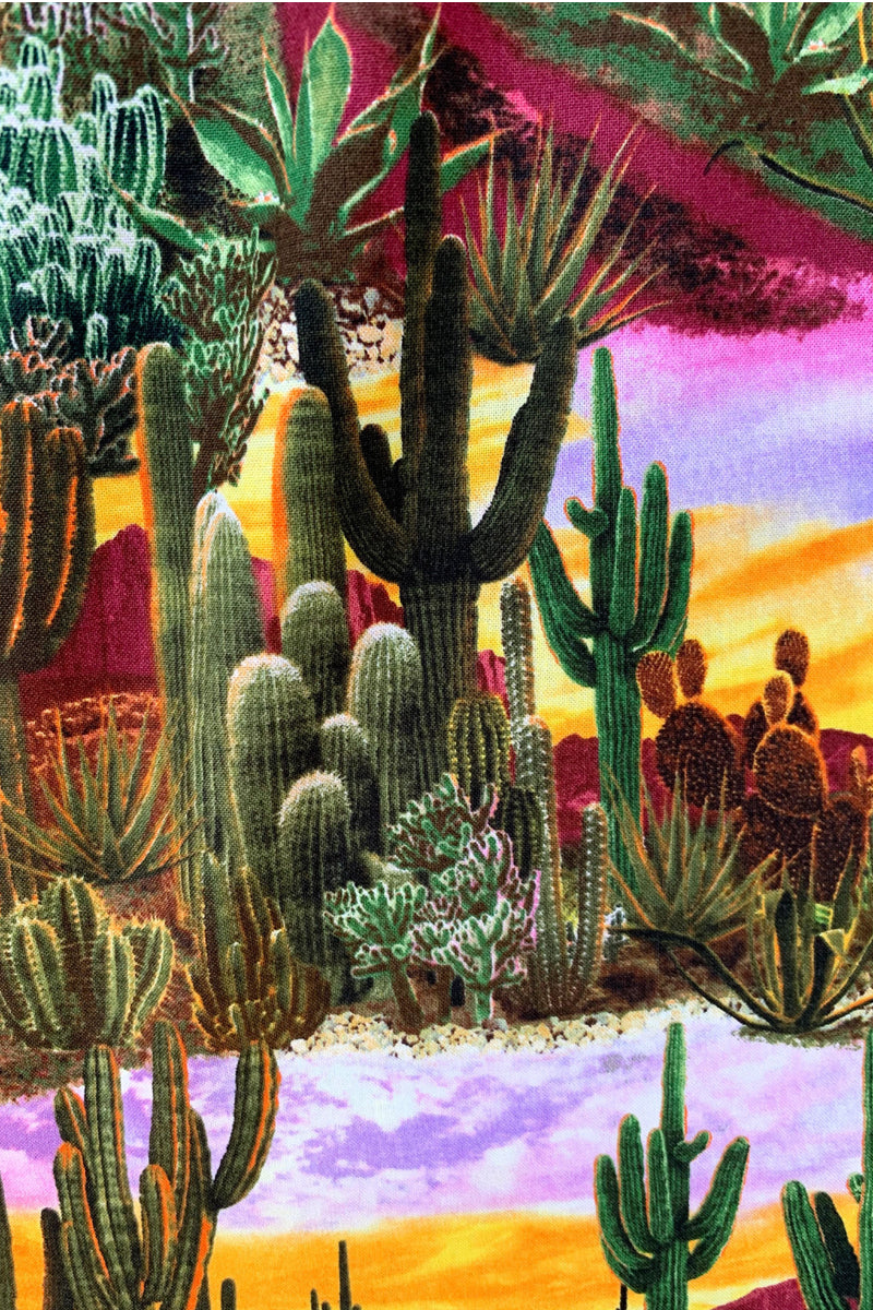 a close up of fabric showing the cacti and sunset colors