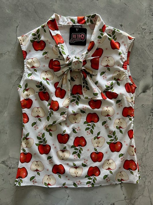 a flat lay of our bow tie blouse with apples and leaves print