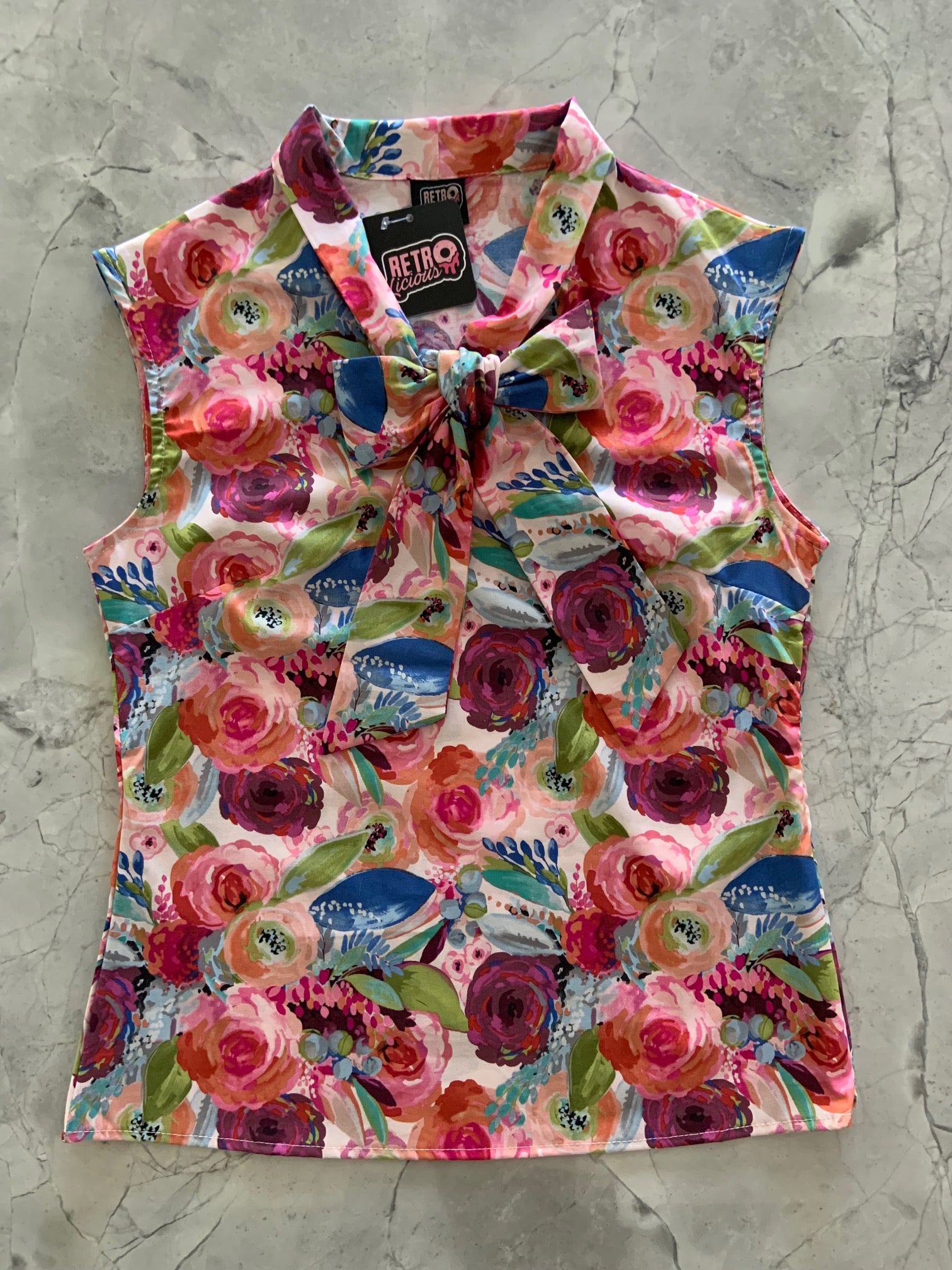a flat lay of the front of the watercolor floral bow top