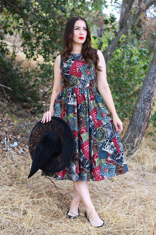 Model wearing dress holding witch hat