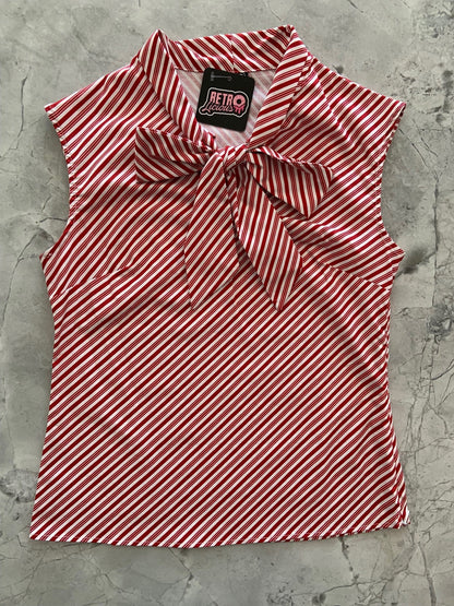 a flat lay of our sleeveless bow tie blouse with candy cane red and with diagonal stripes