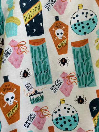 a close up of fabric showing the print of the different bottles of potions