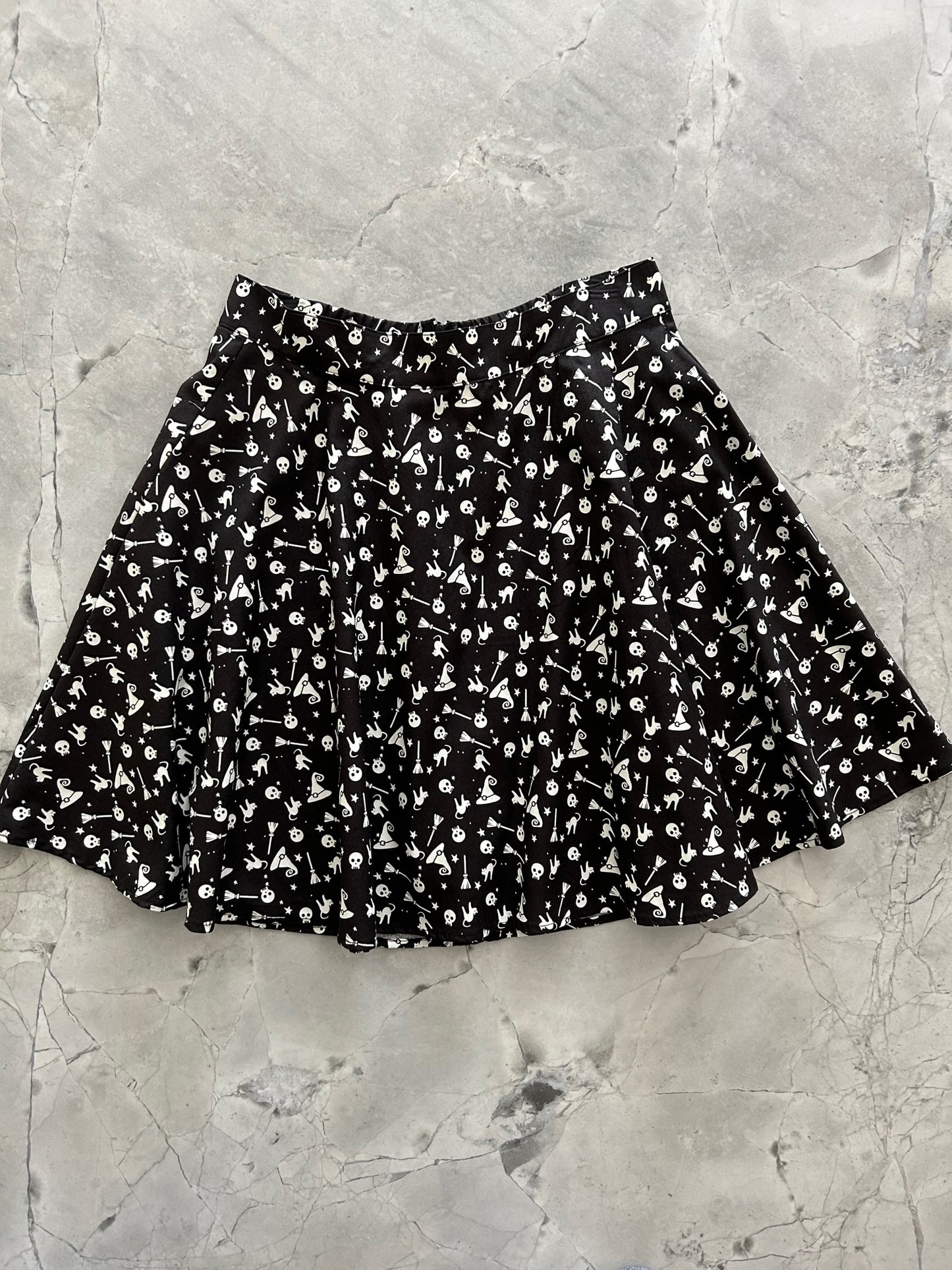 a flat lay of the front of the hocus pocus glow in the dark skater skirt