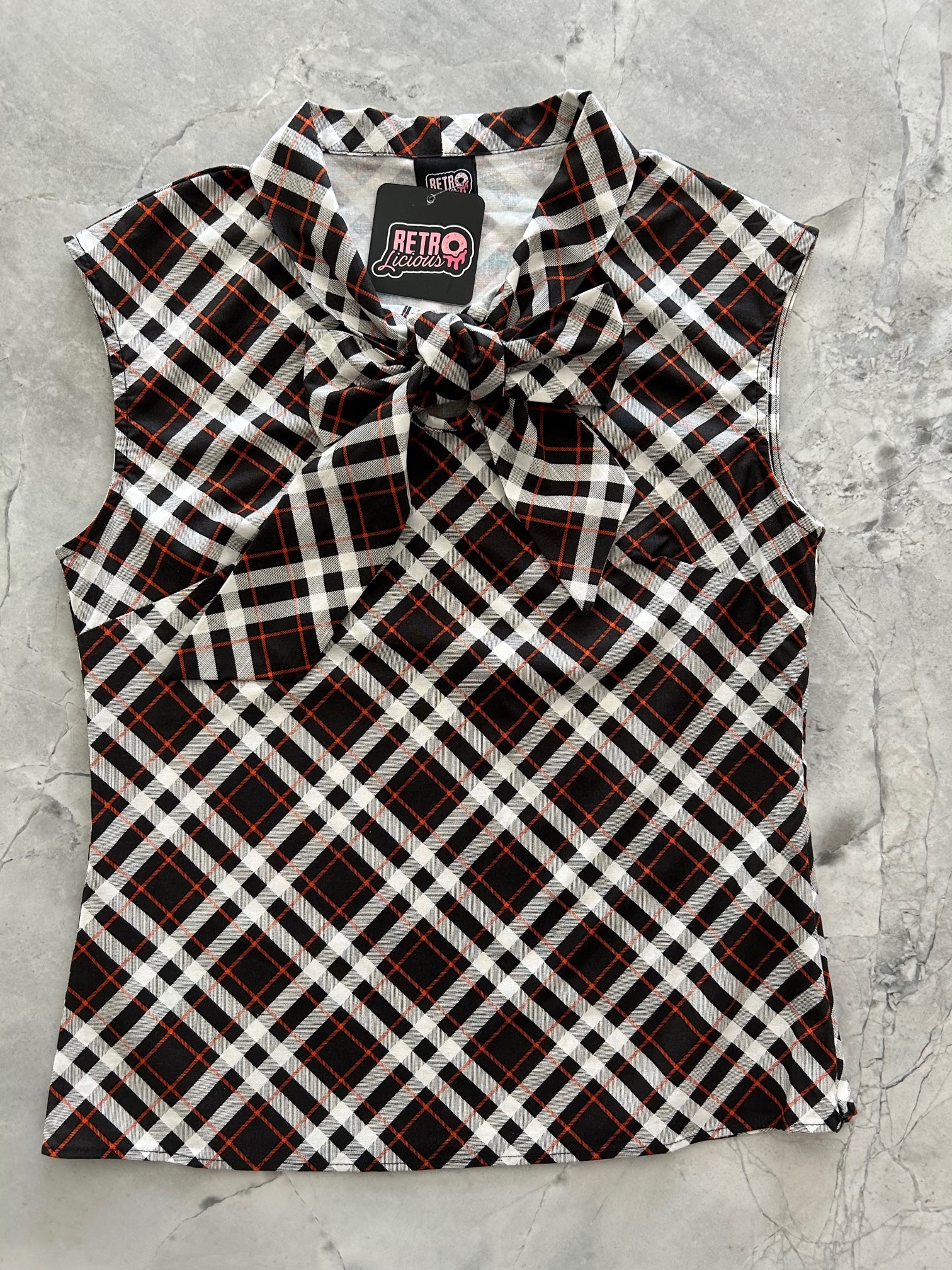 a flat lay image of the front of the plaid bow top