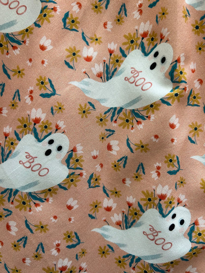 a close up of the swatch of the Elizabeth dress in boo ghosts showing the flying ghosts and with the words BOO on them and the background has flowers