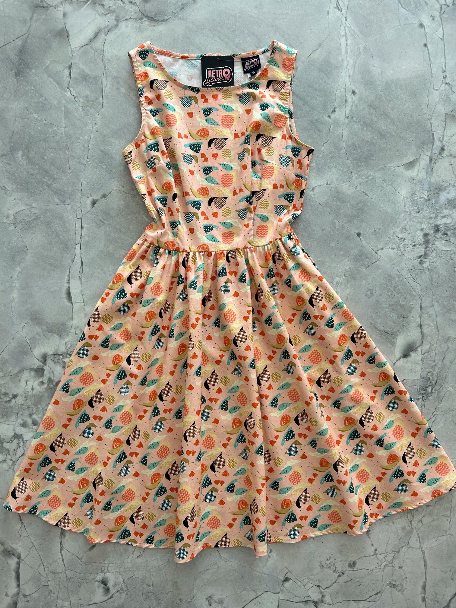 a flat lay image of our Snails Vintage Dress showing the full dress layed out flat