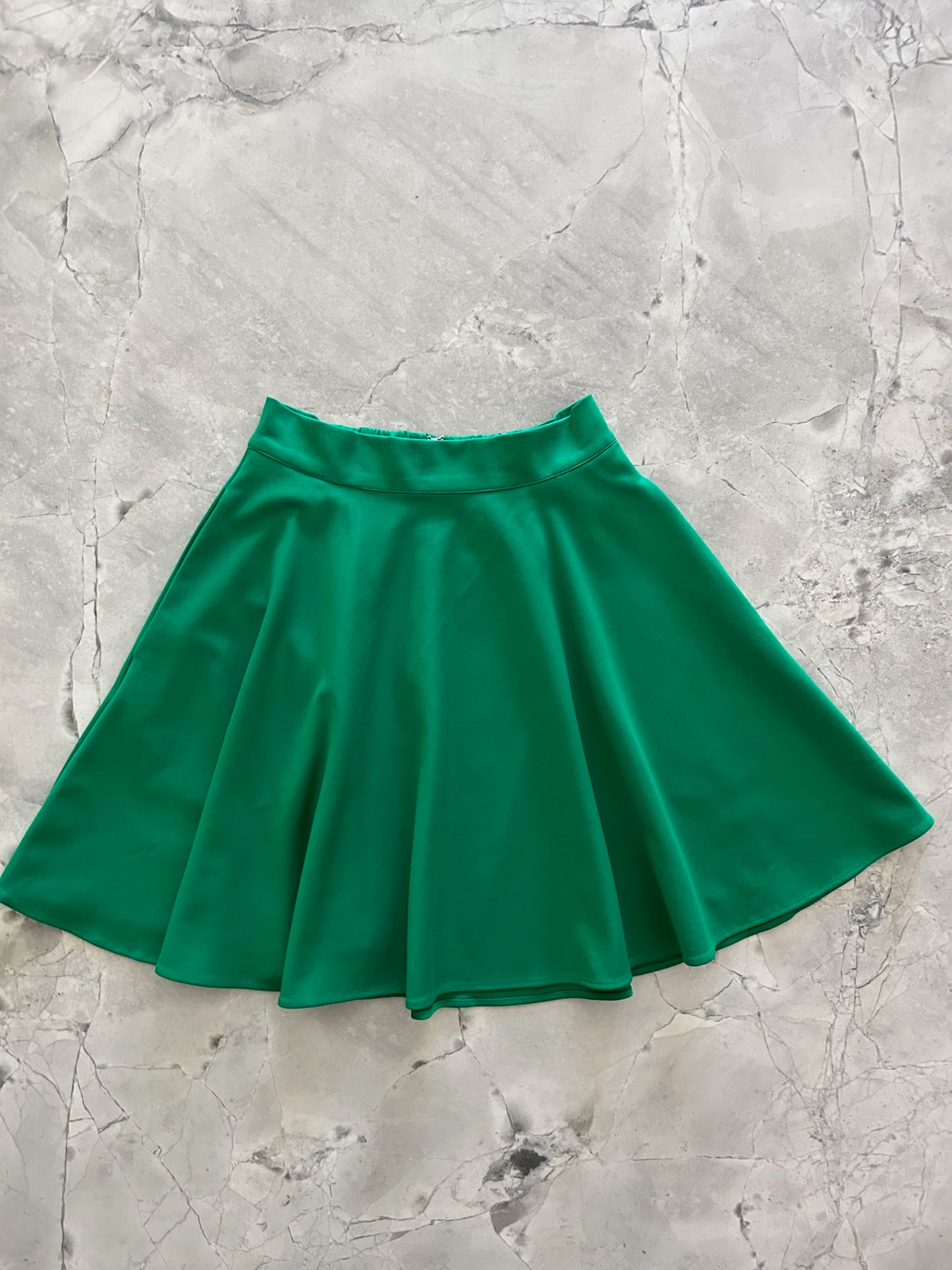 a flat lay image of the front of the harper skater skirt in green