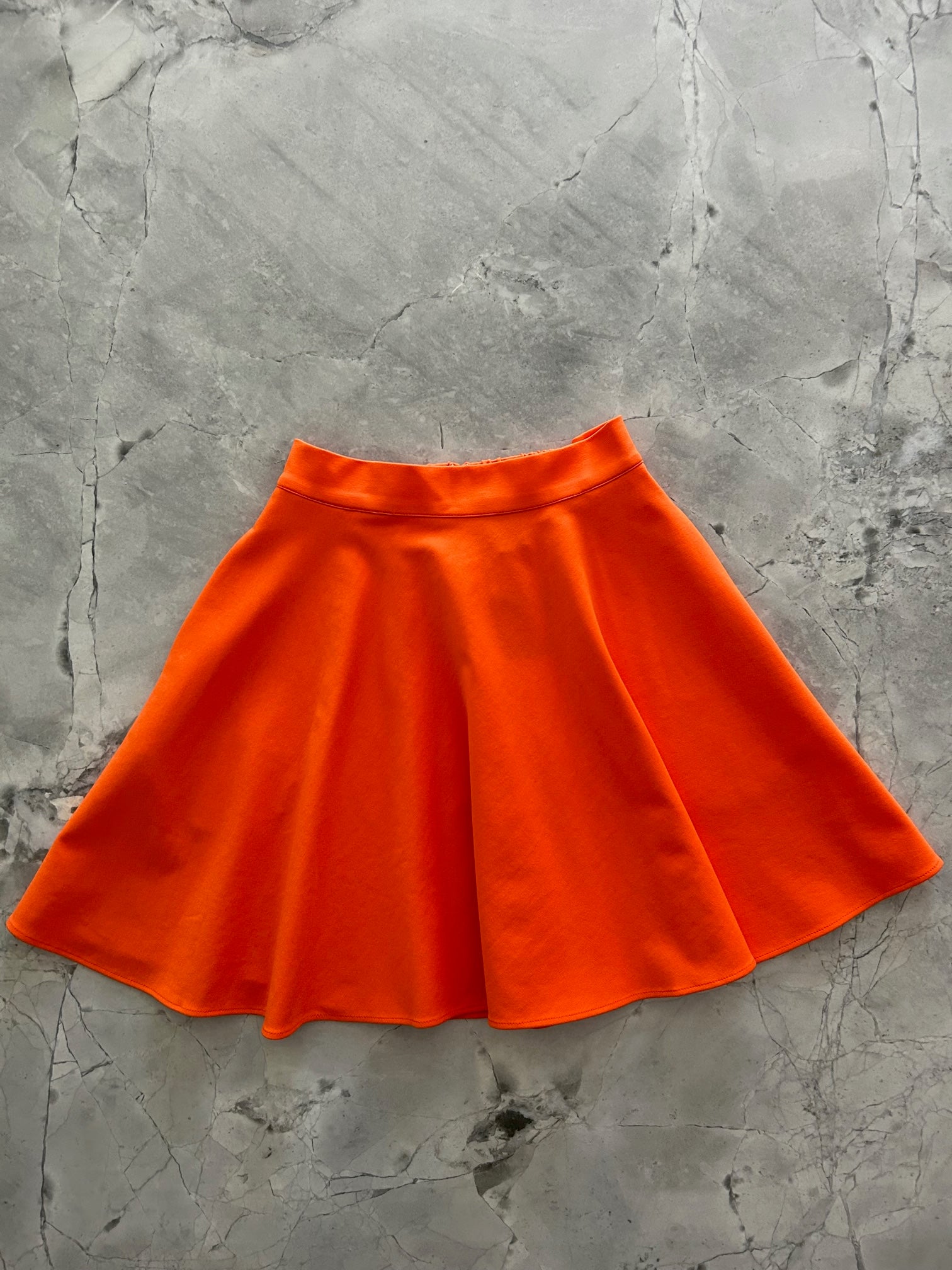 a flat lay image of the front of the harper skater skirt in orange