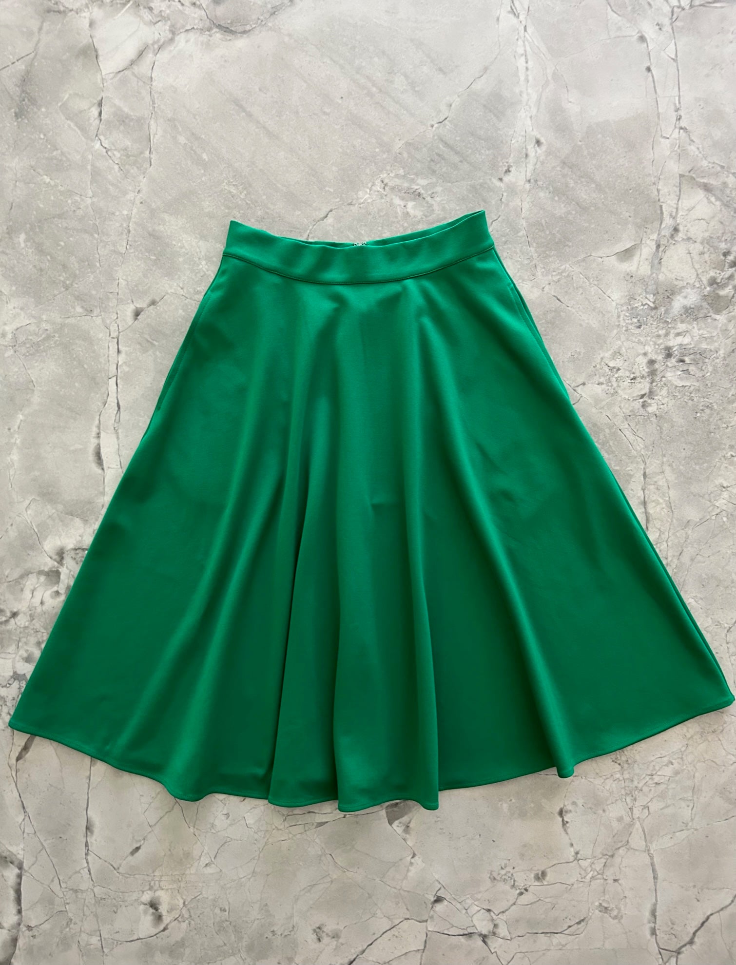 a flat lay image of the front of the Charlotte Nova skirt in green