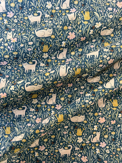 a close up of the fabric showing the pring of cats in fields of flowers