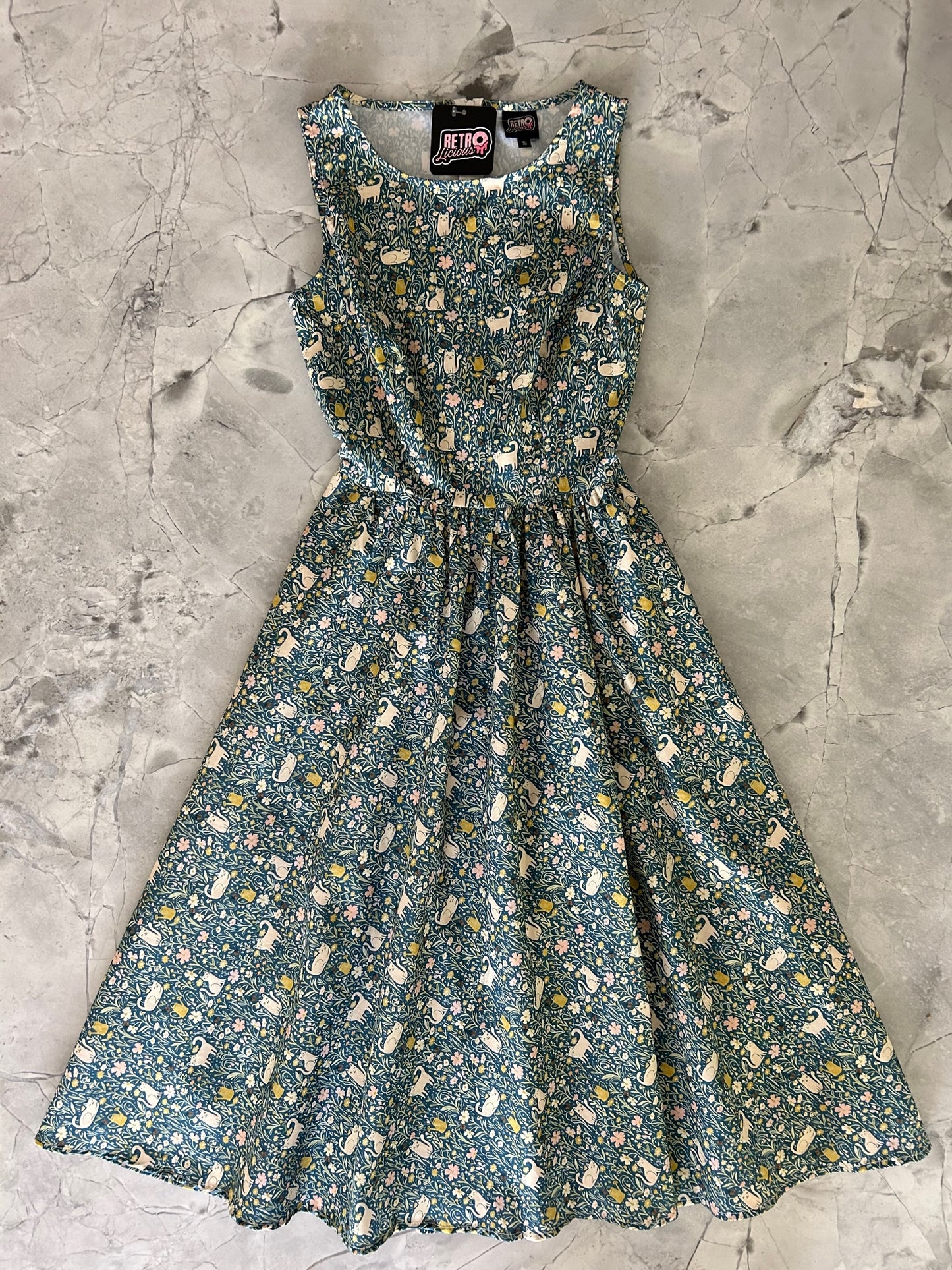 a flat lay of front of our cats and flowers midi dress