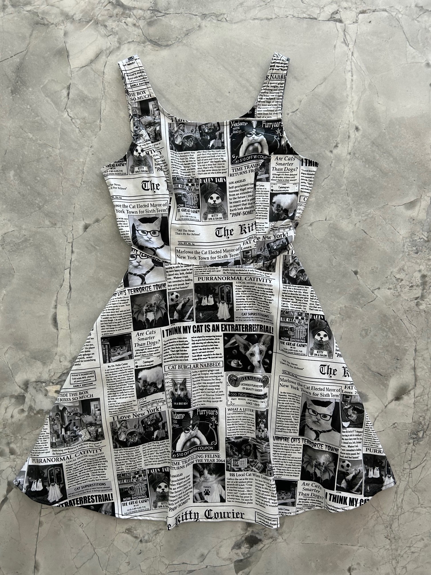 a flat lay image of the front of our Cat Chronicle dress layed out flat