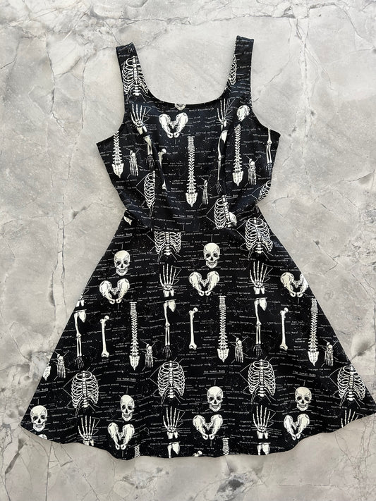 a flat lay image of the front of the Glow Skulls & Bones skater dress layed out flat 