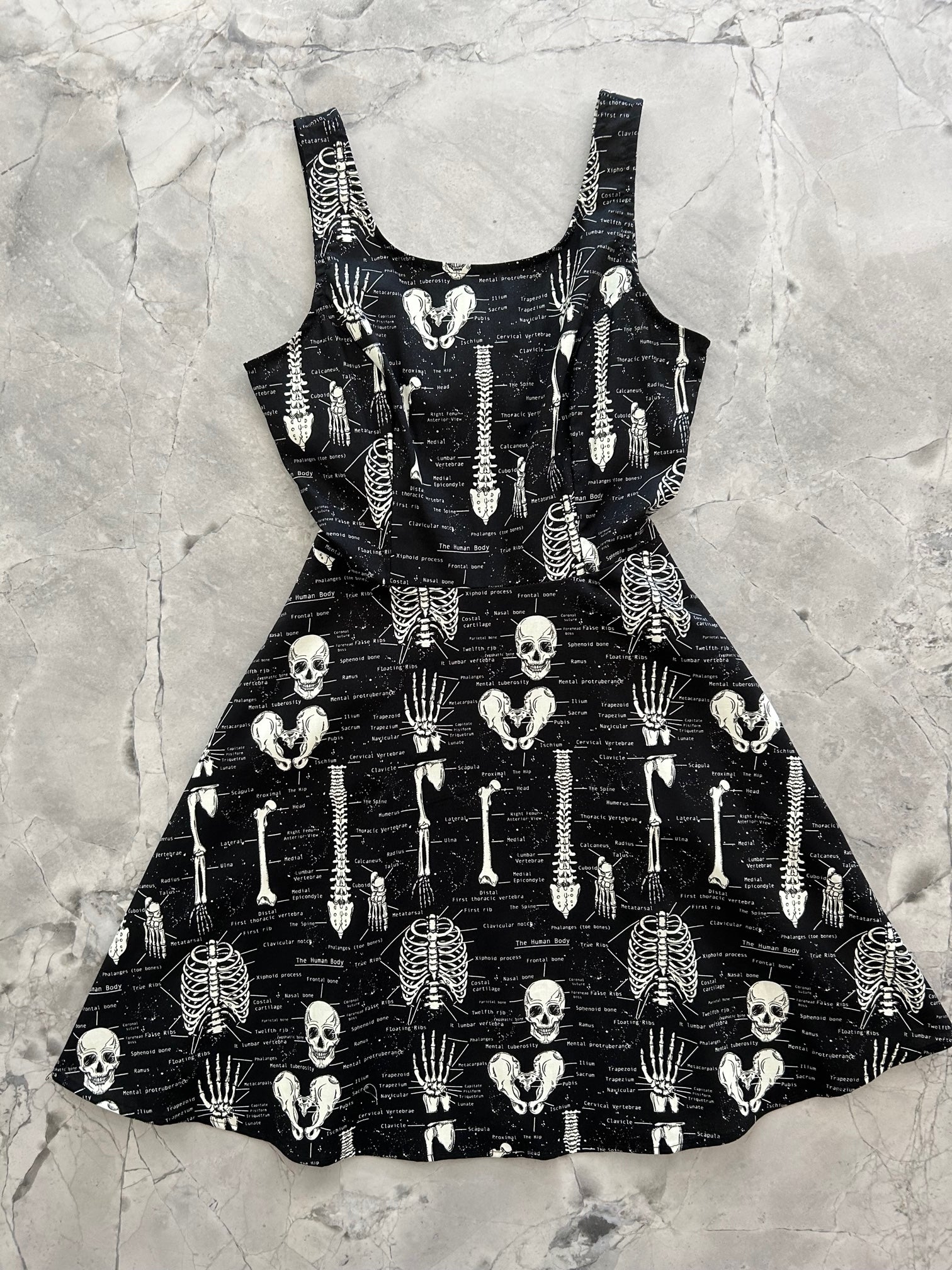 a flat lay image of the front of the Glow Skulls & Bones skater dress layed out flat 