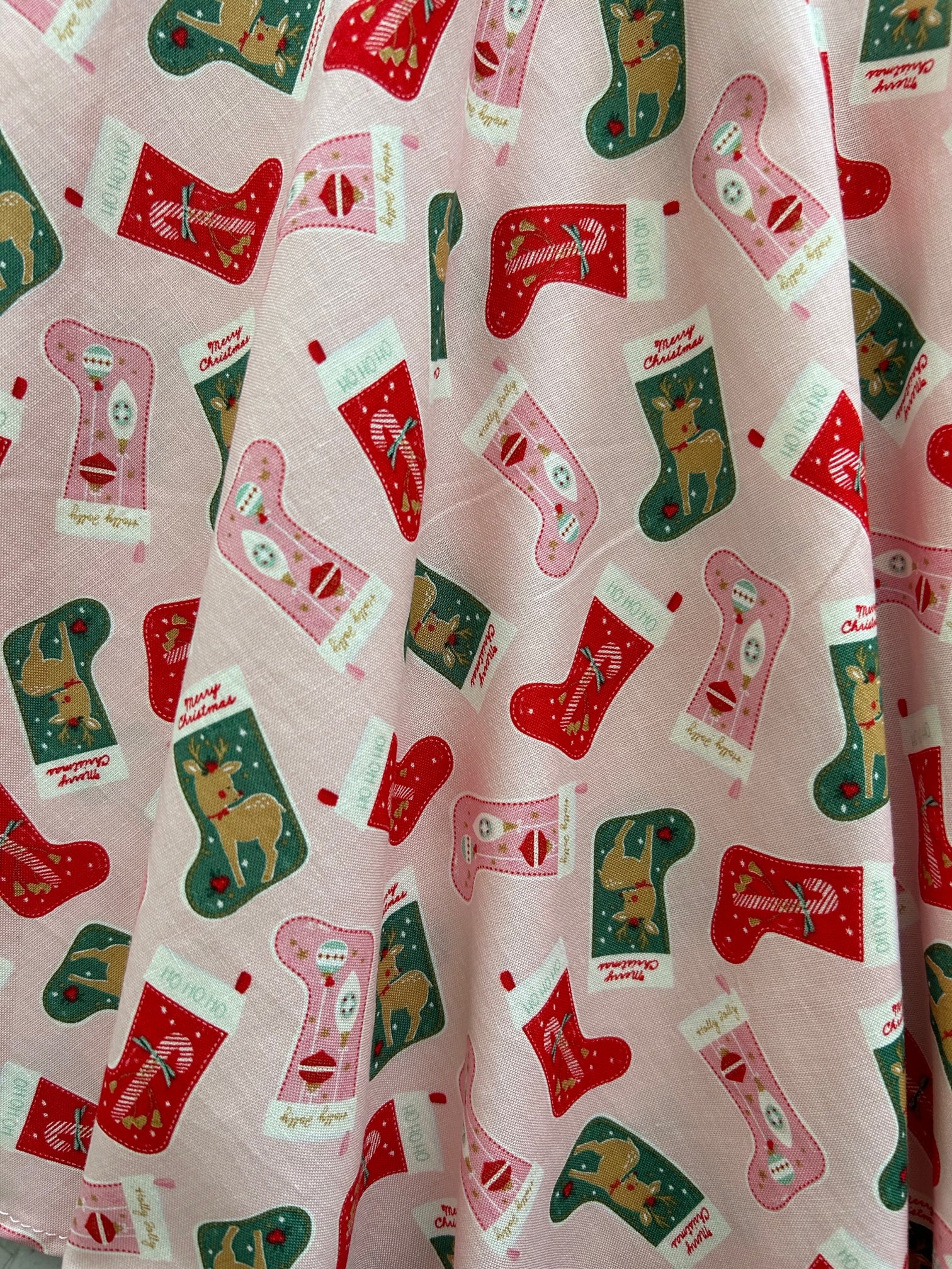 close up of the stockings skater skirt print showing an all over tossed stocking print on pink background