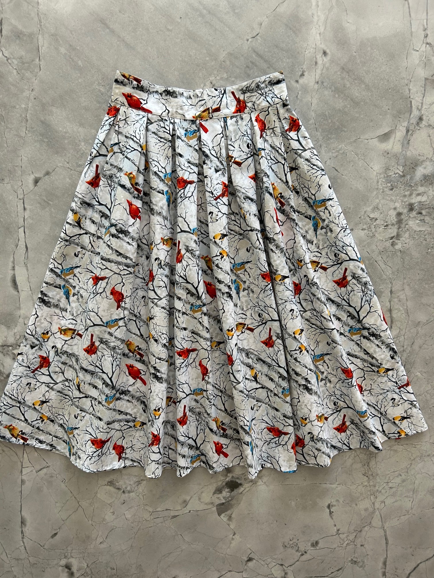 flat lay of a 50s style swing skirt showing a print of birds on birch tree