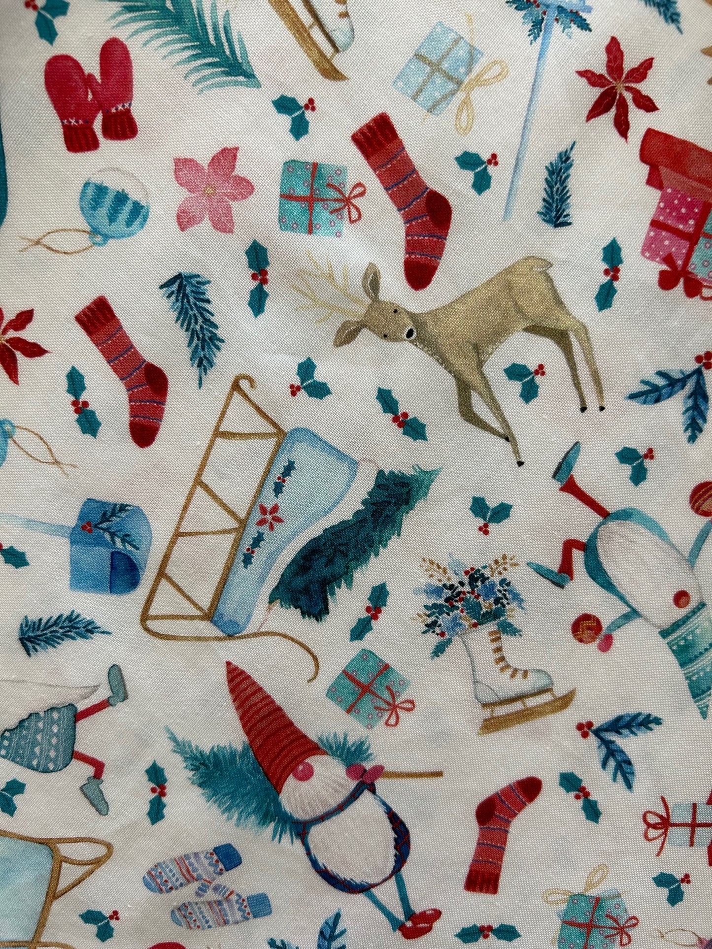 close up of print showing the shirring on the waistline and the print with gnomes, sleds, stockings on white background