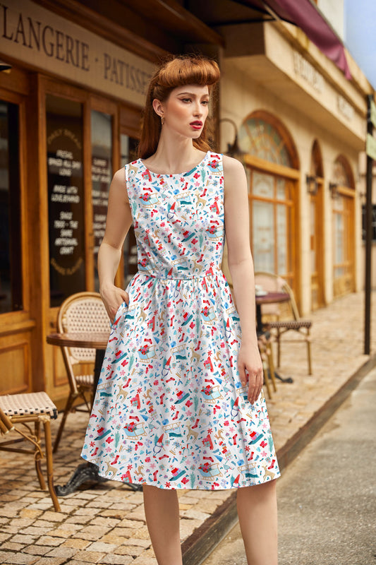 Woman in a patterned dress standing on a street with a café in the background