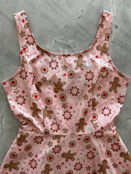 close up of bodice showing the gingerbread man cookies, milk and candy canes on the pink background 