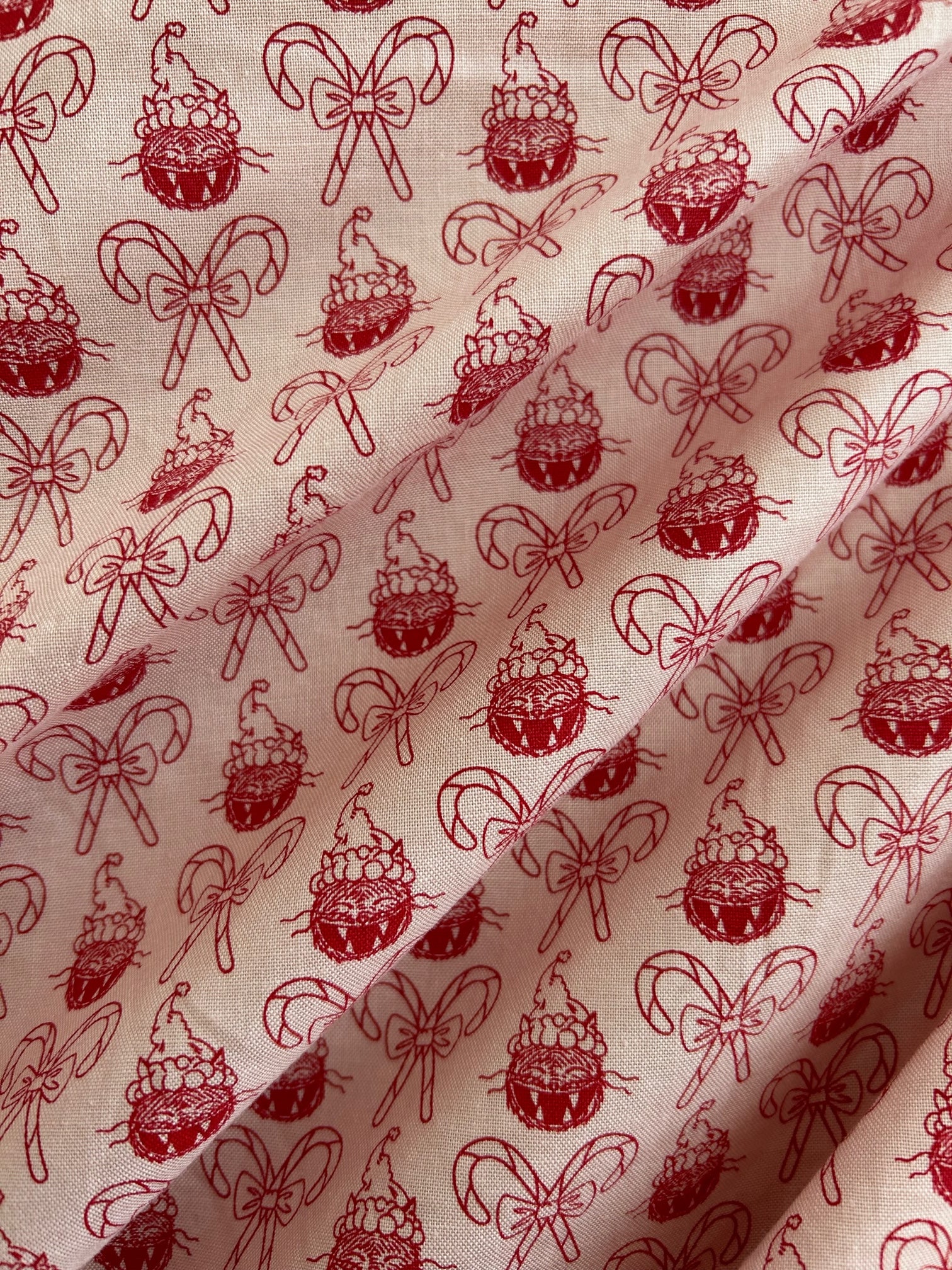 close up of the fabric patterns showing repeating print of cats in holiday hats and candy canes