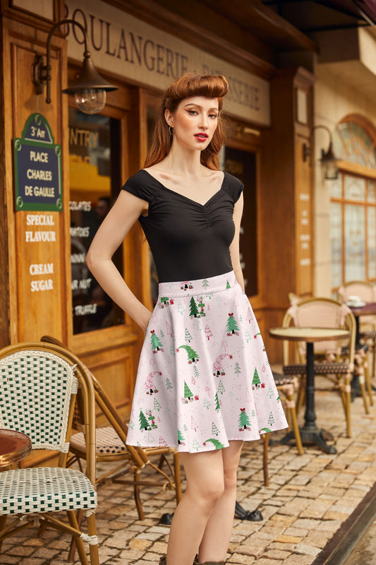 Woman in a black top and patterned skirt standing in front of a bakery wearing gifts skater skirt