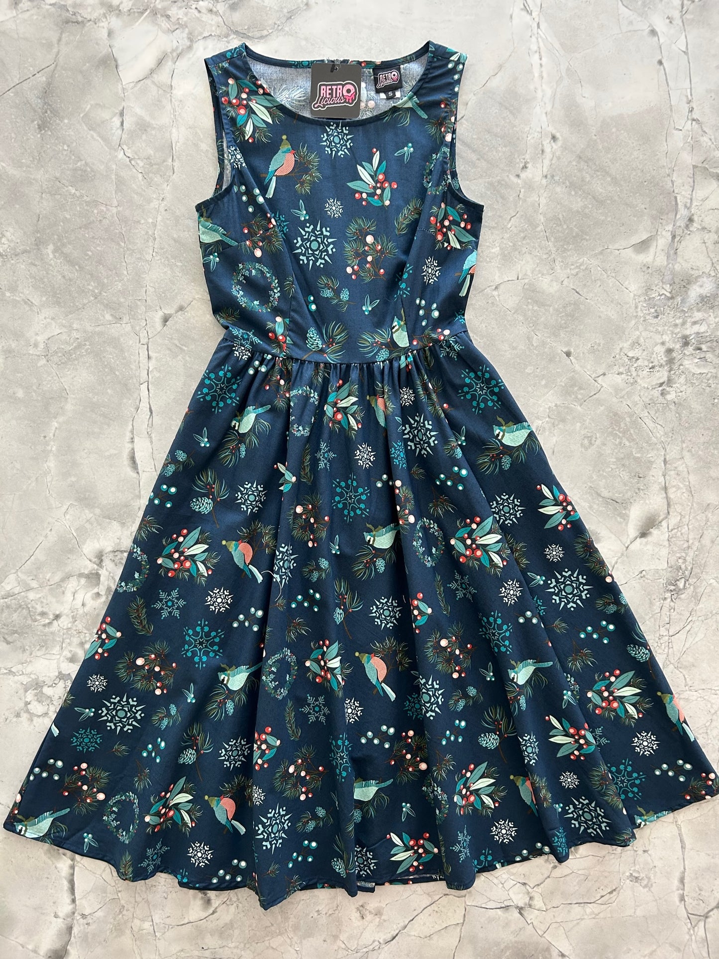 flat lay of holiday birds midi dress showing th dark blue background with a festive bird print