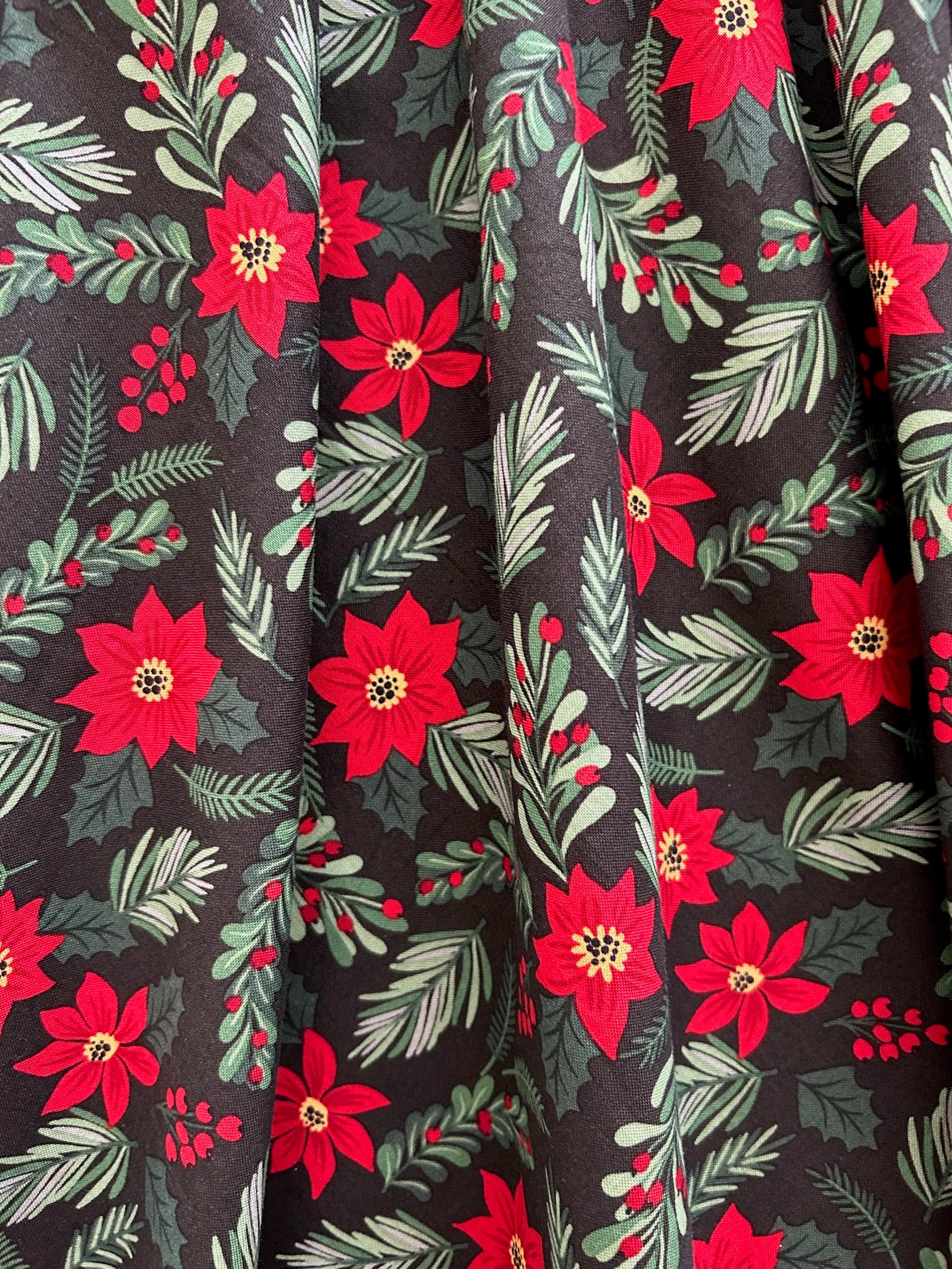 close up of print showing red poinsettias and green branches