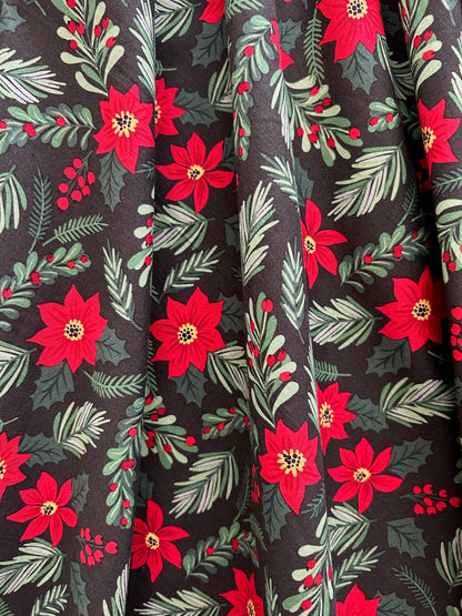close up of print showing red poinsettias and green branches