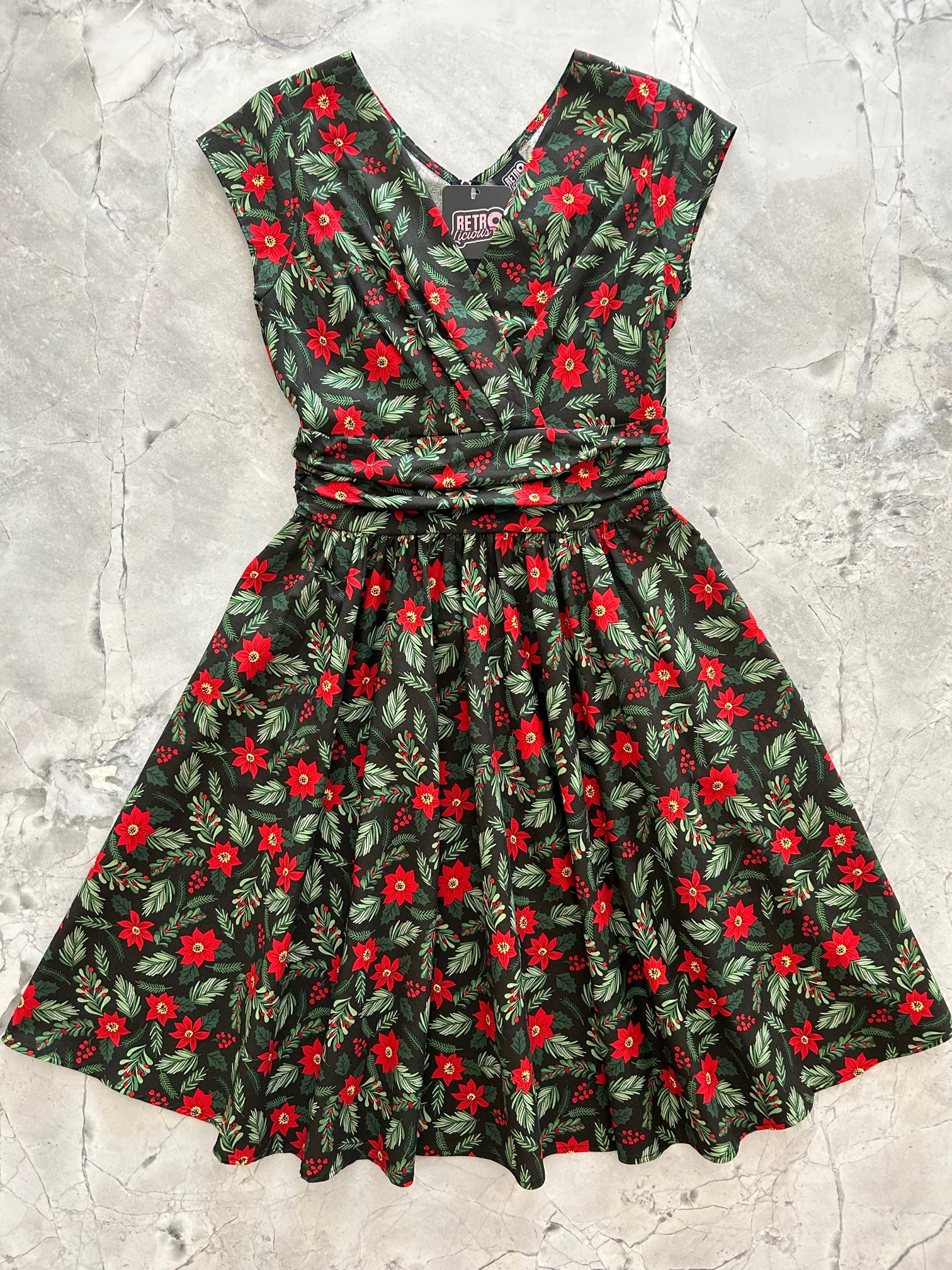 flat lay of vintage style holiday greta dress with poinsettia print